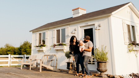 couple and baby in front of shed